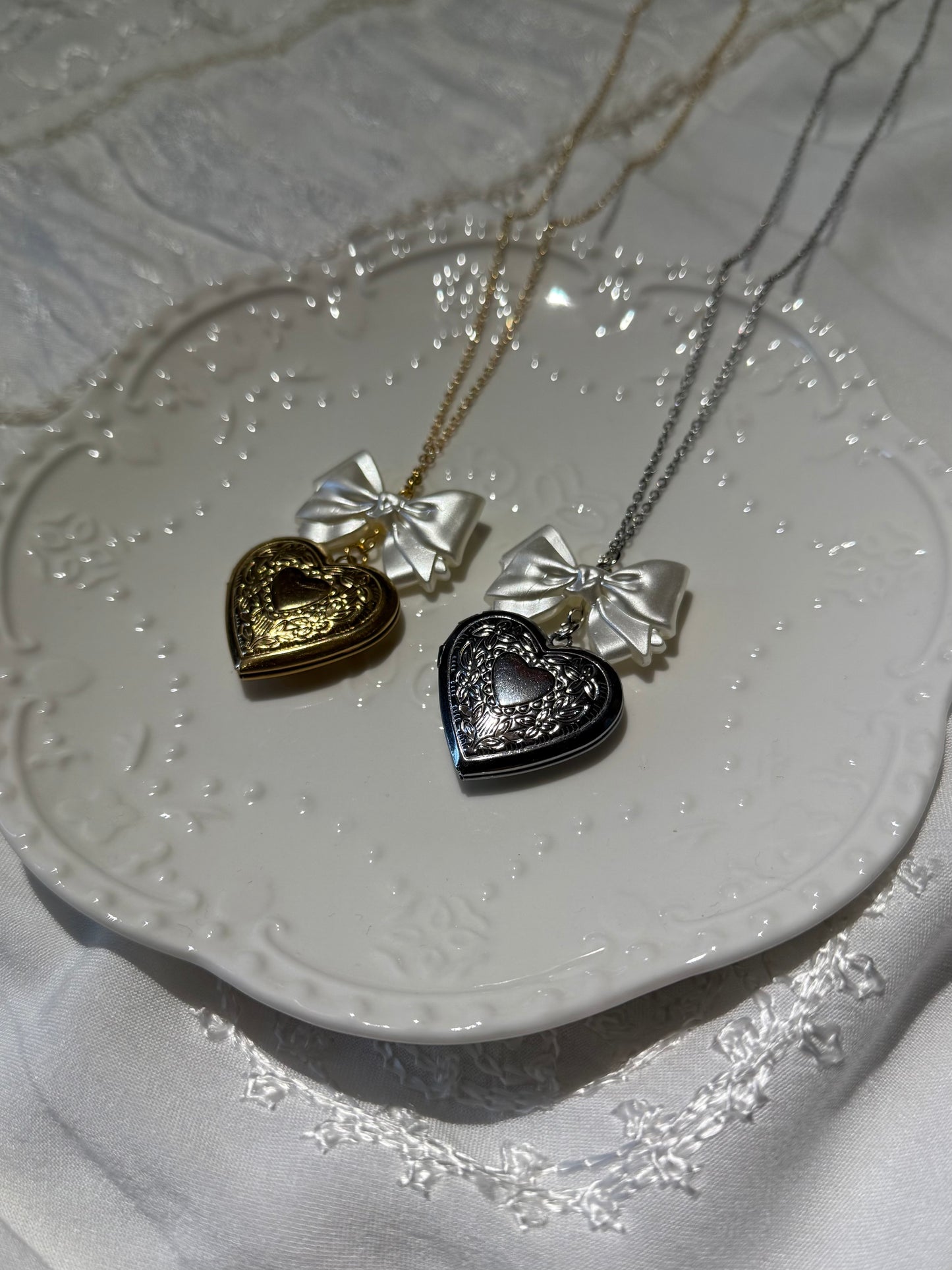 pretty, elegant, heart-shaped pendant locket necklaces in gold and silver with pearl bow charm