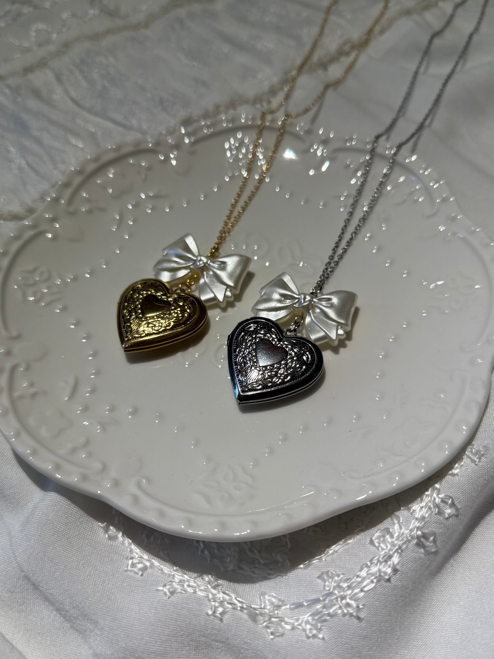 pretty, elegant, heart-shaped pendant locket necklaces in gold and silver with pearl bow charm
