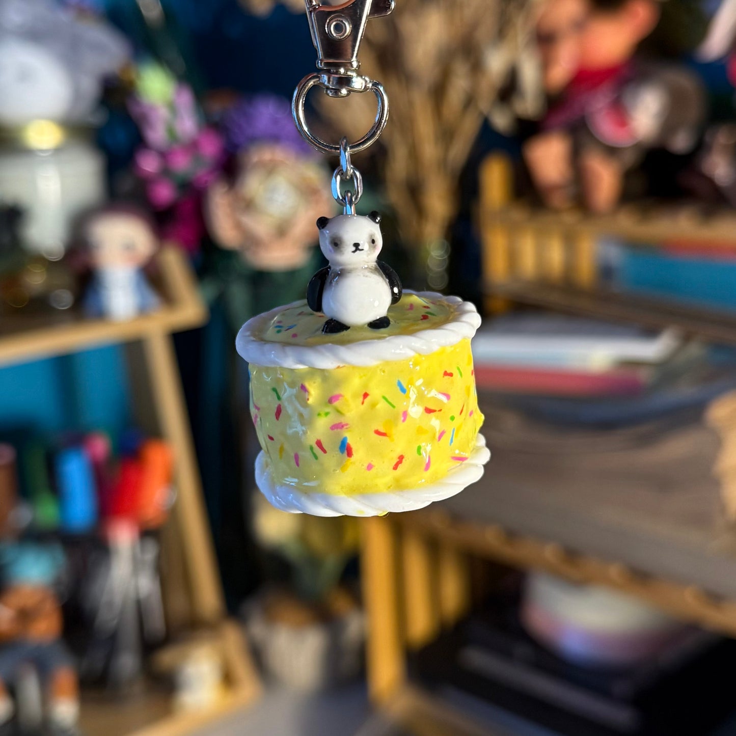 cute keychain with a panda on a yellow birthday cake with sprinkles